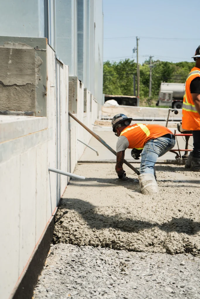 Crew coordinating concrete and paver work on a commercial jobsite